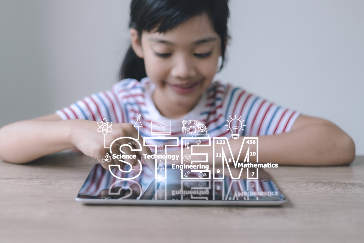 Female child playing with digital device, STEM concept